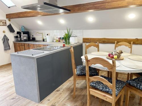 a kitchen and dining room with a table and a stove at Nocleg na skraju puszczy in Ludomy