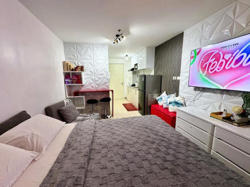 a bedroom with a bed and a large television on the wall at Casa Manawari in Tagaytay