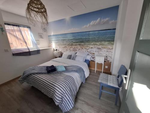 a bedroom with a bed with a painting of the ocean at Sports et détente in Fresse