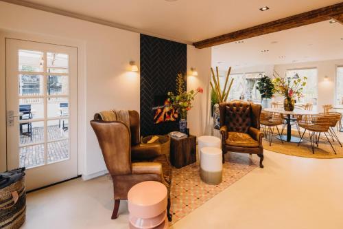a living room with two chairs and a table at Hotel & Brasserie De Boschhoek in Oostkapelle