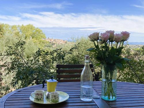 a table with a vase of flowers and a bottle of water at Villa Ceppeto, Best Of Tuscany at Brand New Nest in Monte San Savino
