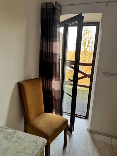 a chair in front of a door with a window at Na Hřebenovce in Krompach