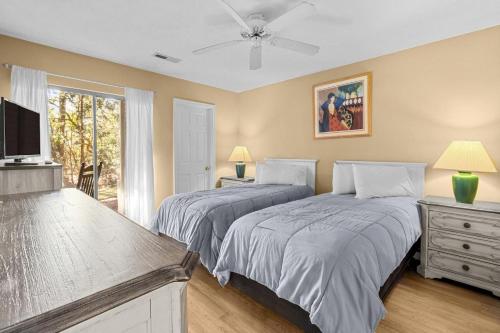 a bedroom with two beds and a tv and a window at 2 Bedroom Golf Villa in Pawleys Island in Pawleys Island