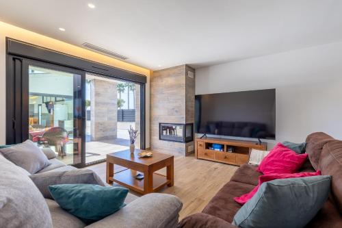 a living room with a couch and a tv at Palm Breeze Villa by Fidalsa in Catral
