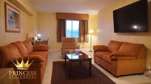 a living room with couches and a flat screen tv at Princess Vegas Hotel & Casino in Corozal