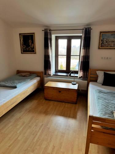 a bedroom with two beds and a window at Na Hřebenovce in Krompach