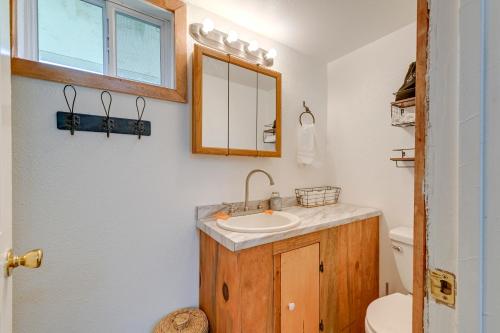 a bathroom with a sink and a mirror and a toilet at Near Rivers and Trails Cabin in Rural Grants Pass in Grants Pass