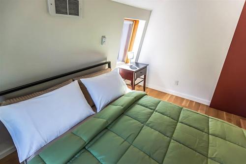 a bedroom with a bed with a green and white comforter at Sqe Arcadian Grove in Sequim