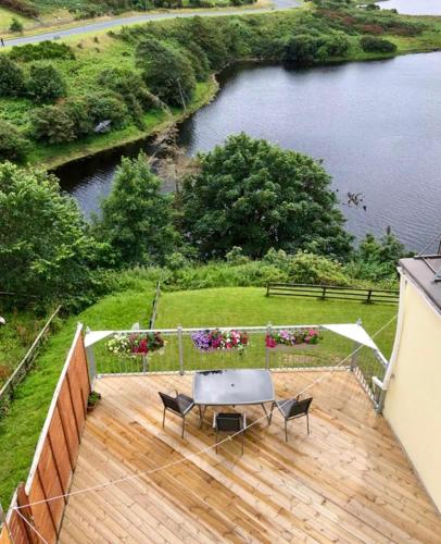 a wooden deck with a table and chairs on it at White Heather House Clifden Town Square in Clifden
