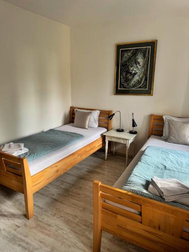 two twin beds in a room with a table at Na Hřebenovce in Krompach