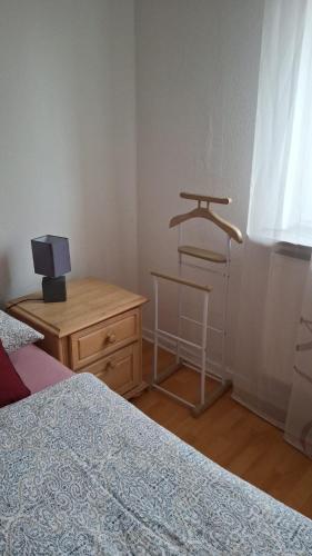 a bedroom with a bed and a table and a stool at Ferienwohnung Eichweg in Bad Sooden-Allendorf