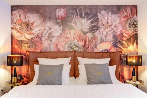 a bedroom with a bed with a floral mural behind it at Blumen(t)raum Ferienwohnung 2 in Karlsruhe