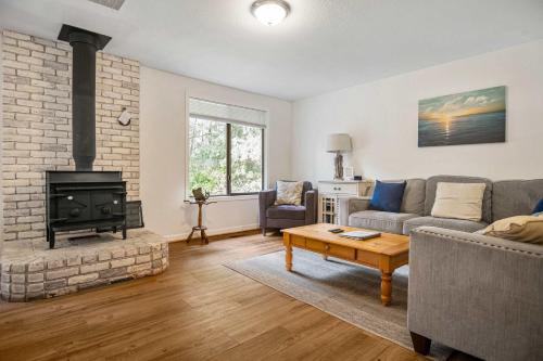 a living room with a couch and a fireplace at #StayInMyDistrict Cozy Rockaway Beach Cottage in Rockaway Beach