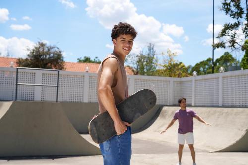 a young man holding a skateboard in a skate park at SESC CONTAGEM in Contagem