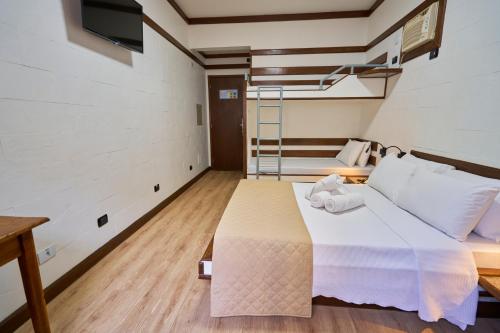 a bedroom with a large bed with white sheets at SESC CONTAGEM in Contagem