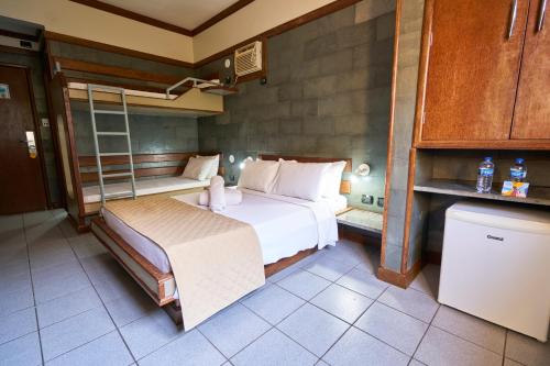a small bedroom with a bed and a kitchen at SESC CONTAGEM in Contagem