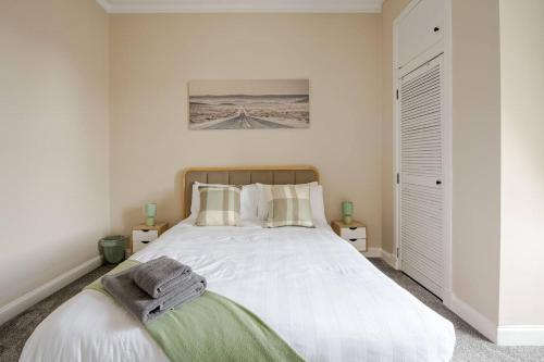a bedroom with a large bed with white sheets at Modern and Stylish 1-Bed Apartment in Dundee City Centre - Perfect for Short or Long Stays & Contractors in Dundee