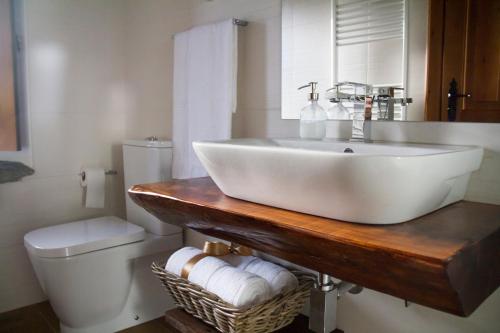 uma casa de banho com um lavatrio branco e um WC. em Refgios do Pinhal em Oleiros