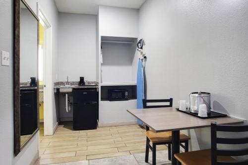 a kitchen and dining room with a table and a table and chairs at Plantation Suites and Conference Center in Port Aransas