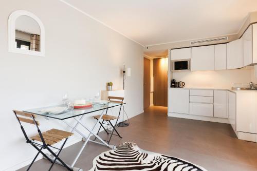 une cuisine et une salle à manger avec une table et des chaises dans l'établissement Le Riviera - Cannes - Croisette - Casino, à Cannes