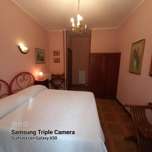 a bedroom with a white bed and a chandelier at villamuna in Ferentillo