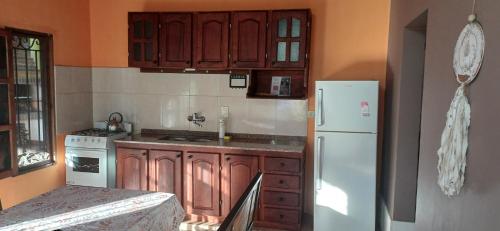 a kitchen with wooden cabinets and a white refrigerator at Residencia céntrica Los crespones in San Ignacio