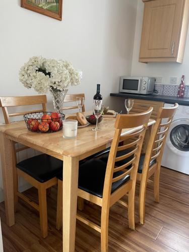 a wooden table with chairs and a vase of fruit at Birch Valley Accommodation Tinahely Wicklow Ireland in Killicreny Bridge