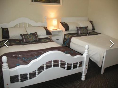 two white beds in a bedroom with a lamp at Birch Valley Accommodation Tinahely Wicklow Ireland in Killicreny Bridge