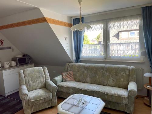 a living room with a couch and two chairs at Haus Mariechen in Hooksiel