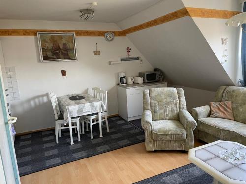a living room with a table and chairs and a kitchen at Haus Mariechen in Hooksiel