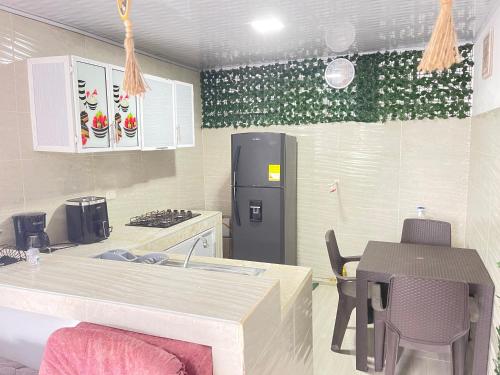 a kitchen with a refrigerator and a table and chairs at La posada in Nuquí