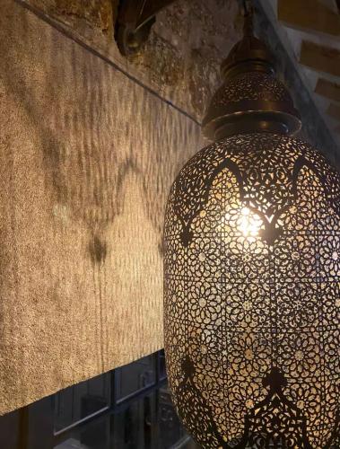 a lamp hanging from a wall in a room at Malouinière Guillaume Onffroy in Saint Malo