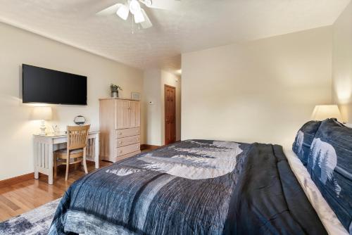 a bedroom with a bed and a desk with a television at Berry Springs Lodge in Sevierville
