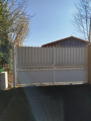 a white fence in front of a house at Gîte des Peupliers in Courlay