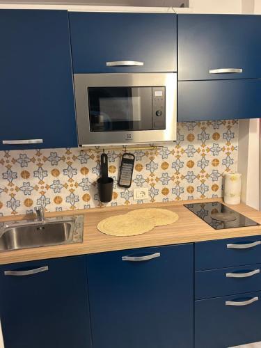 a kitchen with a sink and a microwave at Cappuccino Apartment Sorrento in Sorrento