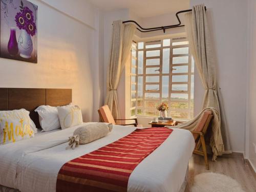 a bedroom with a large bed and a window at Casa Bellà Game View in Nakuru