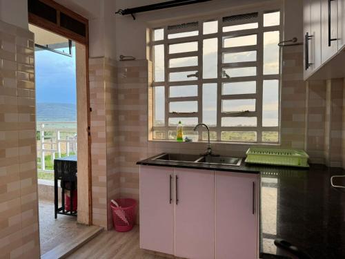 a kitchen with a sink and a window with a view at Casa Bellà Game View in Nakuru
