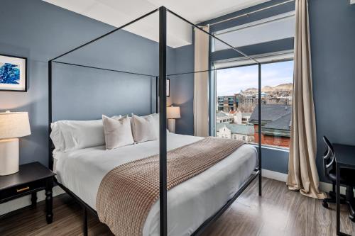 a bedroom with a bed and a large window at Luxury Apt - Penthouse - King Bed Gym Pkg Pool NEW in Salt Lake City