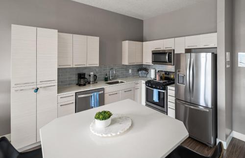 a kitchen with a table with a potted plant on it at Luxury Apt - Penthouse - King Bed Gym Pkg Pool NEW in Salt Lake City