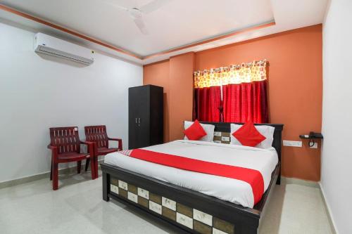 a bedroom with a large bed and two chairs at Super Hotel O New Cyber Grand Madhapur in Hyderabad