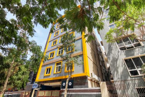a yellow building with windows on a street at Super Hotel O New Cyber Grand Madhapur in Hyderabad