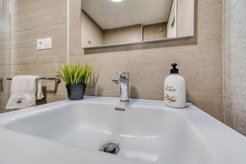 a bathroom sink with a bottle of soap on it at Blue Sunset Retreat in Manilva