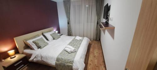 a bedroom with a bed with towels on it at Selina Apart Transilvania in Braşov
