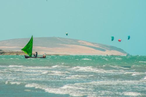 a group of people on a sail boat in the ocean at Vila Beijú BARRINHA - Frente Mar! in Barrinha