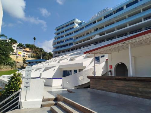 a large cruise ship parked next to a building at Hotel Aristos Acapulco in Acapulco