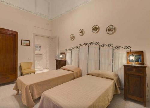 ローマにあるDomus Ottavia in Romaのベッドルーム1室(ベッド2台、椅子付)