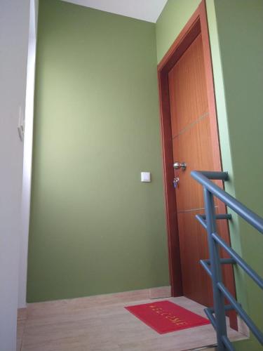 a room with a door and a red rug and a staircase at Ladeira apartamentos in Ribeira Grande
