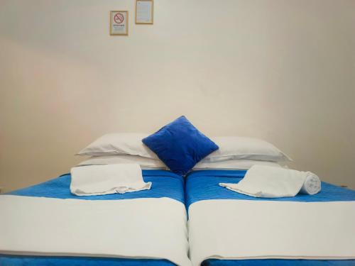 a large bed with blue and white pillows on it at Fatima House in Rome