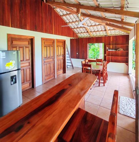 a kitchen and dining room with a large wooden table at Corcovado Green Cabin & House in Drake