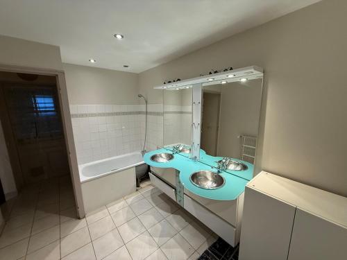 une salle de bain avec un lavabo bleu et un miroir dans l'établissement Appartement moderne avec jardin, quartier calme, à Saint-Claude